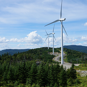 Image showing windmills with mountains in the backgroun and woodlands surrounding them.